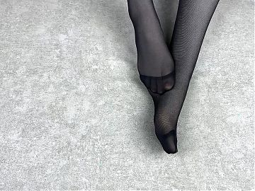 Mistress caresses her feet in black nylon pantyhose